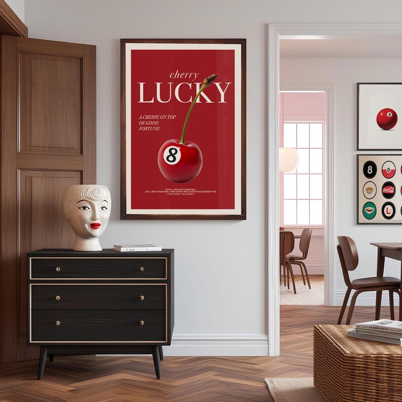 K&ouml;nnte beinhalten: Ein rotes und wei&szlig;es Poster mit dem Text "cherry lucky" und einer Kirsche mit der Nummer 8 darauf. Das Poster ist in braunem Holz gerahmt und h&auml;ngt an einer wei&szlig;en Wand.