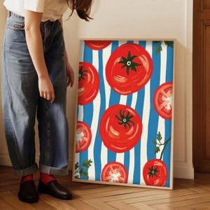 May include: A framed print with a blue and white striped background featuring red tomatoes. The tomatoes are painted in a stylized, whimsical style.