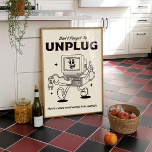 May include: A framed poster featuring a retro cartoon computer character holding a plug, with the text "Don't Forget To UNPLUG" and "There's a whole world waiting to be explored!". The poster is in a kitchen setting with a basket of apples and a bottle of wine.