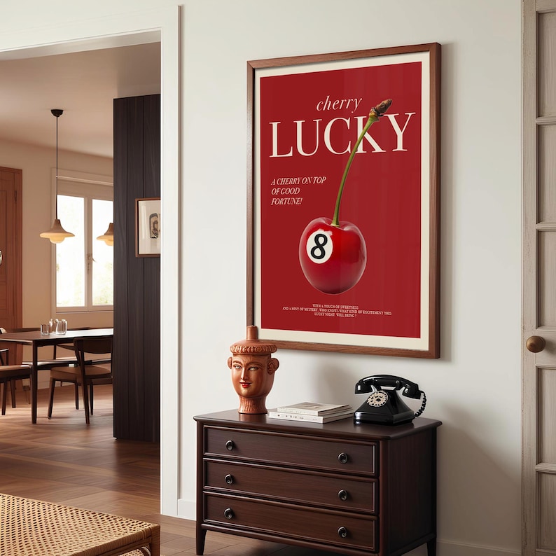 K&ouml;nnte beinhalten: Ein rotes Poster mit dem Text "cherry lucky" und einer Kirsche mit der Nummer 8 darauf. Die Kirsche befindet sich auf einem roten Hintergrund. Das Poster ist in braunem Holz gerahmt.