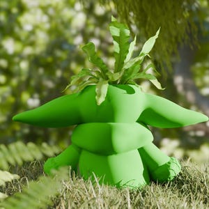May include: A green planter shaped like a character from a popular science fiction franchise, with large ears and a small body. The planter is filled with green leafy plants, and sits in a grassy area with a blurred background of trees.