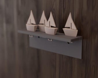 May include: A gray shelf with four small, light-colored sailboat figurines. The shelf is mounted on a dark wood-grain wall. The sailboats have white sails and light-colored hulls. The shelf has a simple, modern design.