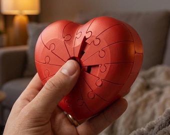 May include: A bright red heart-shaped object constructed from multiple interlocking puzzle pieces. The surface of the heart features a distinct texture with visible lines from the assembly of the individual segments that fit together to form the complete shape.