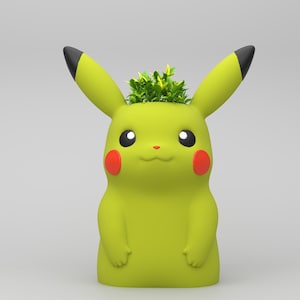 May include: A yellow Pikachu planter with black-tipped ears and red cheeks. The planter is filled with green plants. The design is based on the popular Pok&eacute;mon character. The planter is a decorative item.