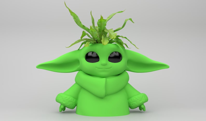 May include: A green planter shaped like a character with large ears and eyes, holding a small plant. The planter has a smooth finish and is filled with green foliage, creating a unique decorative item.