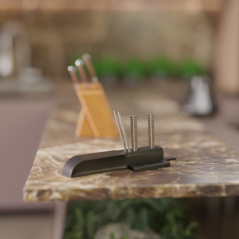 Puede incluir: Un afilador de cuchillos negro con m&uacute;ltiples varillas de afilado verticales. El afilador est&aacute; sobre una encimera de m&aacute;rmol, con un taco de cuchillos de madera y cuchillos al fondo. El afilador est&aacute; dise&ntilde;ado para afilar cuchillos de cocina.