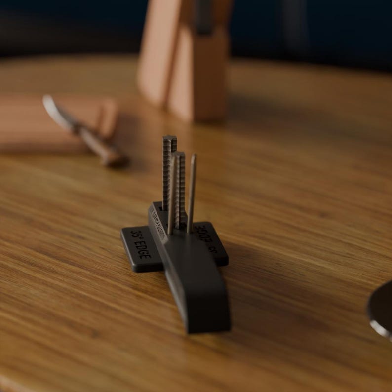 Puede incluir: Un afilador de cuchillos negro con tres varillas met&aacute;licas verticales. La base del afilador tiene el texto "35&deg; EDGE" y "SAFETY GUIDES". Un bloque de cuchillos de madera y un cuchillo est&aacute;n en el fondo.