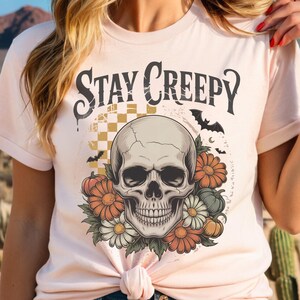 Add spooky vibes to your Halloween creations with this Stay Creepy PNG. Featuring a skeleton hand and dripping heart in a retro grunge style, perfect for sublimation, t-shirts, mugs, stickers, and trendy Halloween designs. 🎃 Digital download only.