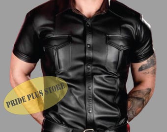 May include: A black leather short-sleeved shirt with a button-up front and two flap pockets. The shirt has a collar and is made of a smooth, shiny material.