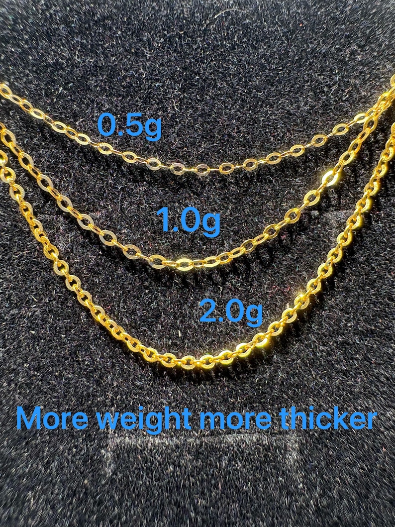 May include: Three gold-colored metal chains of varying thicknesses arranged in a cascading pattern. The chains are labeled with the weights 0.5g, 1.0g, and 2.0g, with the text "More weight more thicker" displayed at the bottom of the image.