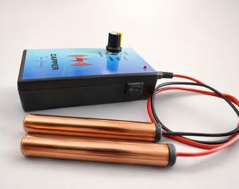 Op de afbeelding: Een zwart elektronisch apparaat met een blauw verloop op het bovenpaneel, het label ZAPPER en een rood bliksempictogram. Het heeft een zwarte draaiknop, een klein rood indicatielampje en een zijschakelaar. Twee koperen cilinders zijn verbonden met rode en zwarte draden.
