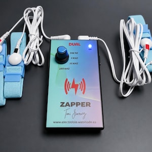 May include: A rectangular electronic device labeled DUAL ZAPPER with a blue control knob, a glowing blue power light, and frequency settings. It is connected by white cables to four light blue elastic straps with white circular electrodes.