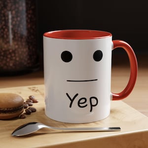 May include: White ceramic mug with a red rim and handle. The mug features a simple black face with a straight line mouth and the word "Yep" written below it.