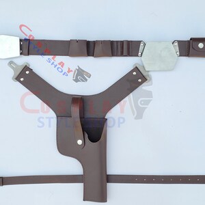 Op de afbeelding: Een bruine leren cosplay riem- en holsterset. De riem heeft zilverkleurige rechthoekige en zeshoekige gespen. De holster is ontworpen om een rekwapen te bevatten. De set bevat een schouderharnas en een tailleband.