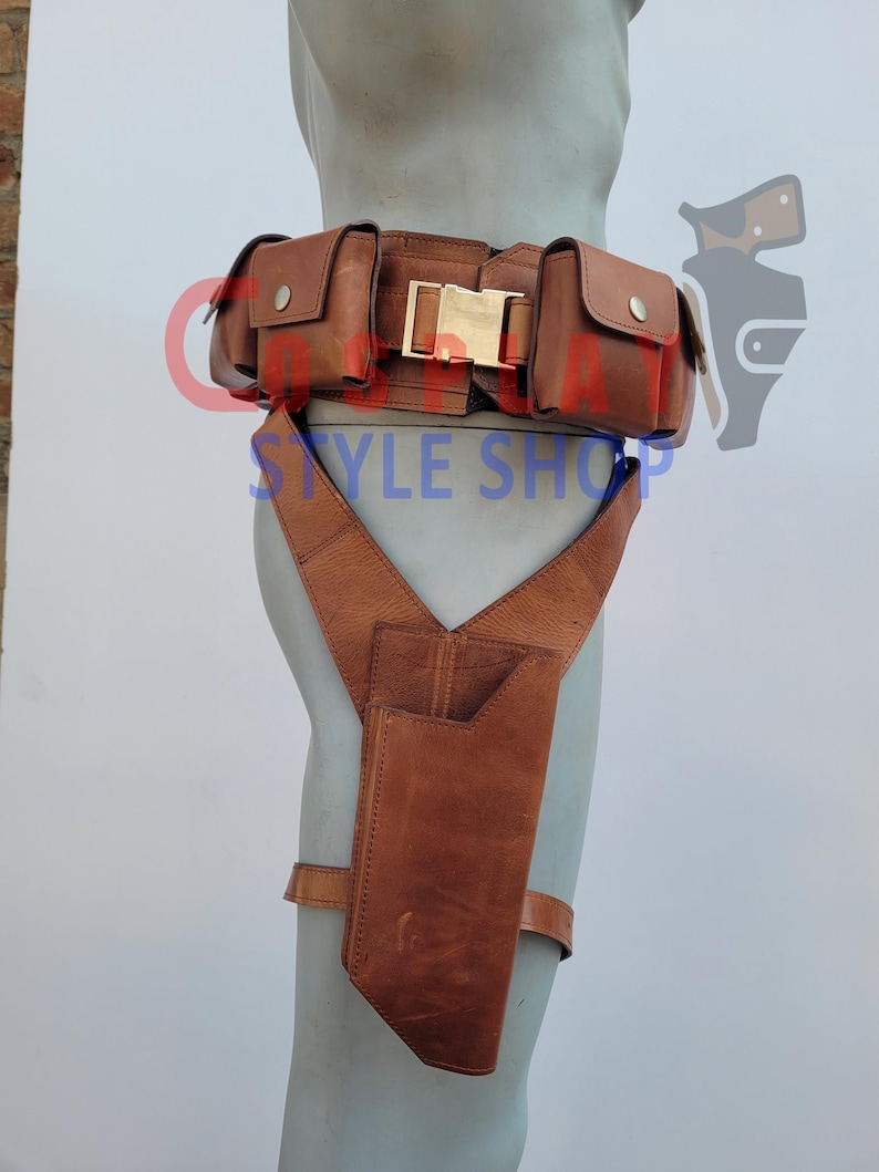 May include: Brown leather utility belt with multiple pouches and a gold-colored buckle. The belt includes a holster attached to suspenders. The text "STYLE SHOP" is visible on the belt.