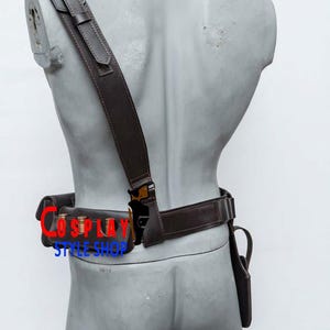 May include: A dark brown leather harness and belt set featuring a shoulder strap, a waist belt with three metallic bullet-shaped cartridges, and a holster attachment. The text COSPLAY STYLE SHOP is printed in red and blue across the belt area.
