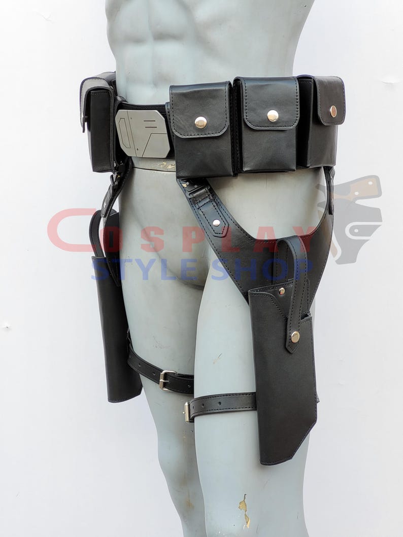 Puede incluir: Cintur&oacute;n utilitario de cuero negro con m&uacute;ltiples bolsas y fundas. El cintur&oacute;n presenta una hebilla de color plateado y est&aacute; dise&ntilde;ado para usarse alrededor de la cintura y las piernas. Las bolsas se aseguran con broches dorados.