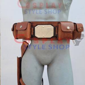 May include: A brown leather utility belt with multiple pouches and a holster. The belt features a rectangular silver buckle and is designed to be worn around the waist. The text "COSPLAY STYLE SHOP" is visible in the background.