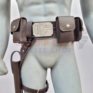 May include: A brown leather belt with a silver buckle and multiple pouches. The belt has a thigh holster attached to it.