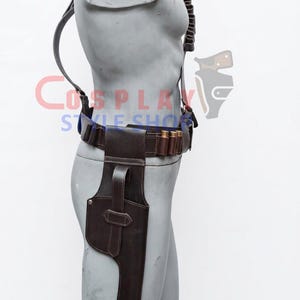 May include: A dark brown leather holster rig featuring a belt with integrated ammunition loops holding metallic cartridges, a shoulder strap, and a vertical side holster with a securing strap, displayed on a grey mannequin torso.