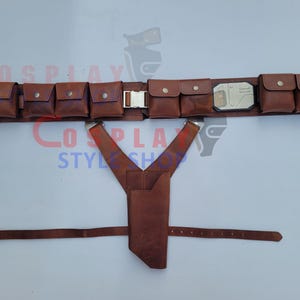 May include: A brown leather utility belt with multiple pouches and a silver buckle. The belt includes a holster and suspenders. The belt is designed for cosplay or costume use.
