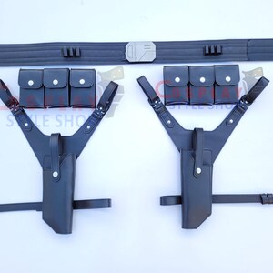 Puede incluir: Un conjunto de cintur&oacute;n y funda de cuero negro. El conjunto incluye un cintur&oacute;n ancho con una hebilla plateada, dos fundas de hombro y dos juegos de tres peque&ntilde;as bolsas. Las fundas tienen una correa que se conecta a un cintur&oacute;n.