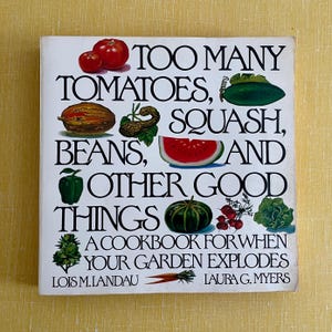 May include: A cookbook titled "Too Many Tomatoes, Squash, Beans, and Other Good Things." The cover features illustrations of various vegetables, including tomatoes, squash, and beans, with the text "A Cookbook for When Your Garden Explodes."