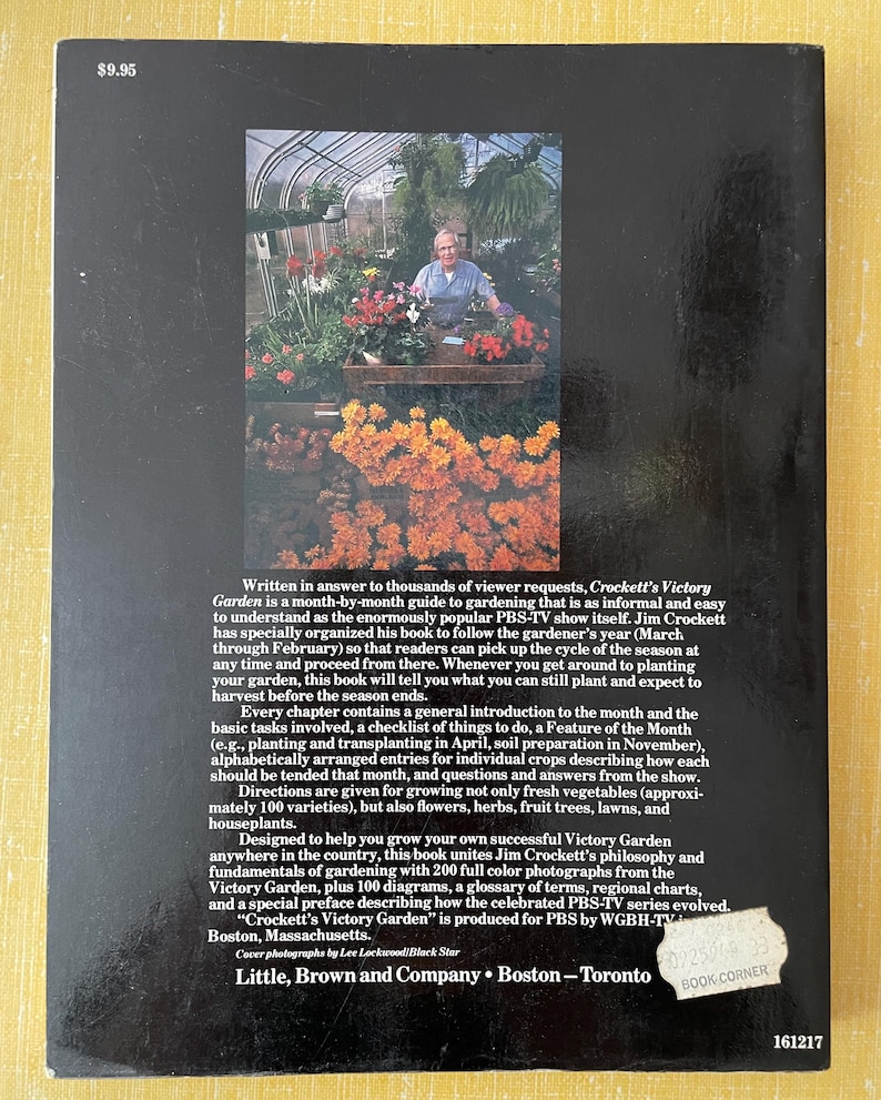 May include: The back cover of the book Crockett's Victory Garden features a black background with white text and a central color photograph of a person in a greenhouse surrounded by flowers. A price of $9.95 is printed in the top left corner.