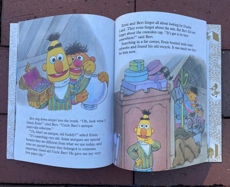 May include: A children's book illustration featuring Sesame Street characters Bert and Ernie. Bert and Ernie are shown in a colorful scene with text from the story. The book is open, displaying the artwork and text.