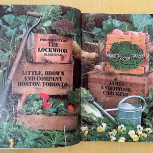 May include: A book spread featuring wooden crates filled with fresh vegetables, a garden fork, and a metal watering can. Text on the crates includes Photography by Lee Lockwood, Little, Brown and Company, and Crockett's Victory Garden by James Underwood Crockett.