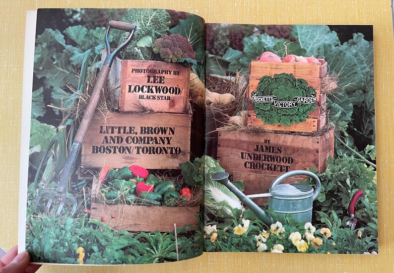 May include: A book spread featuring wooden crates filled with fresh vegetables, a garden fork, and a metal watering can. Text on the crates includes Photography by Lee Lockwood, Little, Brown and Company, and Crockett's Victory Garden by James Underwood Crockett.