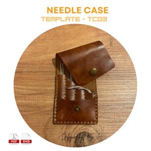 Puede incluir: Un estuche de agujas de cuero marrón con una solapa que se abre para revelar un juego de agujas. El estuche está sobre una superficie de madera. El texto "NEEDLE CASE TEMPLATE - TC03" está en la parte superior de la imagen. El texto "Designed by UKS" está en la parte inferior de la imagen.