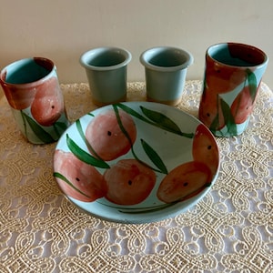 Juego artesanal de 5 piezas: cuenco, dos tazas y dos difusores de té en color verde azulado claro y diseño de amapola roja.