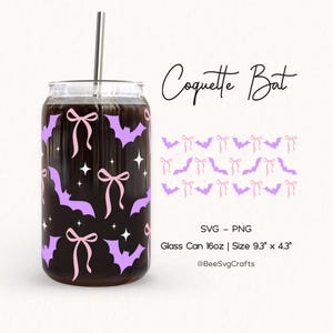 May include: A glass can with a stainless steel straw, decorated with purple bats, pink bows, and white stars. The text "Coquette Bat" is written in a script font. The can is 9.3" x 4.3" and holds 16oz.