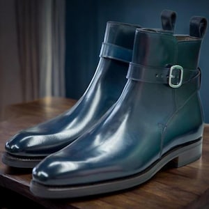 May include: A pair of dark blue leather ankle boots with a buckle strap. The boots have a pointed toe and a low heel.