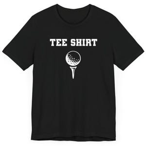 May include: Black t-shirt with white text that says "TEE SHIRT" and a white golf ball graphic.