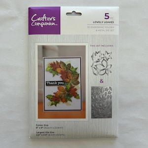 May include: A Crafter's Companion 5-piece Lovely Leaves 3D embossing folder and metal die set in original packaging. The package displays a finished card with autumn leaves and the text Thank you, plus dimensions of 6 inches by 9 inches.