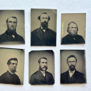 May include: Six antique portrait photographs featuring men with beards and formal attire. The images are rectangular, with a sepia tone and visible wear, suggesting they are vintage. The men are wearing suits and jackets.