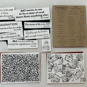 May include: A collection of rubber stamps featuring various inspirational quotes by artists and writers, a small stack of books, a butterfly pattern, and a travel-themed design with multiple postmarks on a tan backing sheet and white paper.
