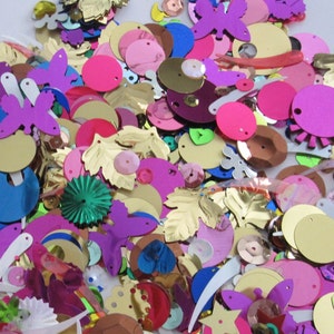 May include: Assortment of colorful sequins in various shapes, including circles, leaves, butterflies, and stars. The sequins are made of shiny, metallic material and are perfect for crafting and decorating.