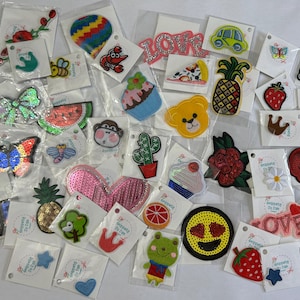 May include: Assortment of colorful iron-on patches featuring various designs, including animals, food, hearts, and words. The patches are perfect for adding a personal touch to clothing, bags, and other accessories.