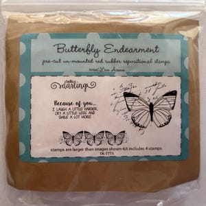 May include: A package of four pre-cut un-mounted red rubber repositional stamps featuring a butterfly design. The stamps are titled "Butterfly Endearment" and include the text "Because of you... I laugh a little harder, cry a little less and smile a lot more." The package is labeled "Artist: Lisa Arane" and "UK-777A".