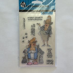 May include: Clear stamp set by Art Impressions featuring illustrations of a woman with cats. The set includes stamps with phrases like "Crazy Cat Lady" and "OCD: Obsessive cat disorder." The package includes 8 pieces.
