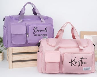 Può includere: Due borse da viaggio personalizzate, una lavanda e una rosa. Ogni borsa ha una tasca frontale e un manico superiore. La borsa lavanda è etichettata "Brook CANCUN 2025" e la borsa rosa è etichettata "Kristin". Entrambe le borse hanno un'etichetta "BUGINGTHO".