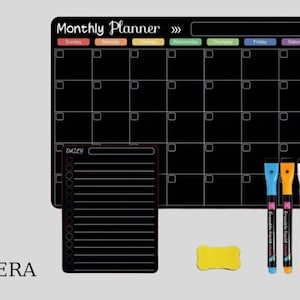 Może przedstawiać: Czarny miesięczny planer z układem siatki, mniejszym codziennym notatnikiem i trzema kolorowymi markerami. Planer ma u góry napis "Monthly Planner" oraz dni tygodnia w różnych kolorach. Dołączona jest również żółta gumka do ścierania.