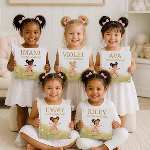 May include: Five children holding personalized storybooks titled with names Imani, Violet, Ava, Emmy, and Riley. Each book cover features the text You Are Amazing! and an illustration of a cartoon character in a pink dress in a field.