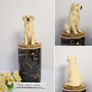 May include: A black and gold marble urn with a wooden lid. A small, cream-colored dog figurine sits on top of the lid. The urn has a bone-shaped plaque with the inscription "Molly 2015-2024".
