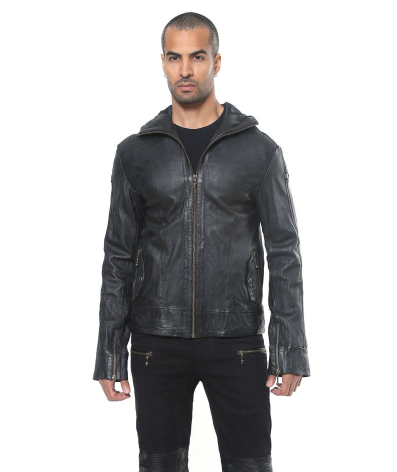 May include: A black leather jacket with a zipper closure and a stand-up collar. The jacket has two zippered pockets on the front and two zippered pockets on the sleeves.