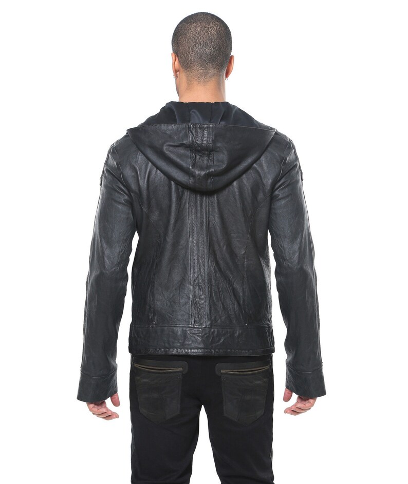 May include: A black leather jacket with a hood. The jacket has a zipper closure and two pockets on the front. The jacket is worn by a person standing with their back to the camera.