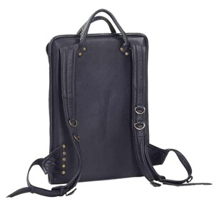 May include: Black leather backpack with adjustable straps and metal hardware. The backpack has a flap closure and a zipped pocket on the front.